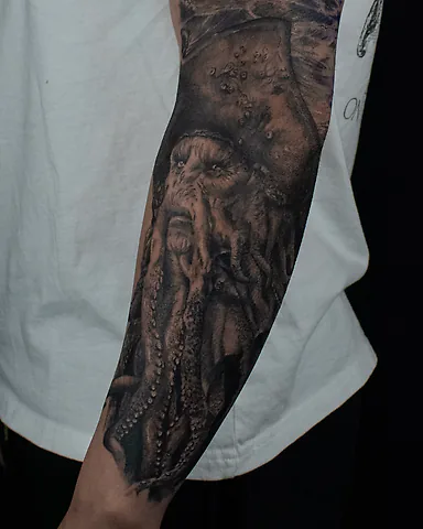 Realistic black and grey Davy Jones portrait forearm tattoo, by Domi (based in Coventry, UK)