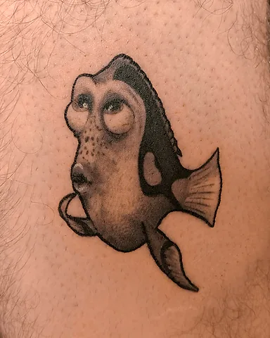 Black and grey Dory from Finding Nemo leg tattoo, by Domi (based in Coventry, UK)