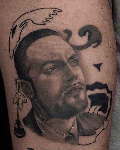 Realistic black and grey Mac Miller portrait thigh tattoo, by Domi (based in Coventry, UK)