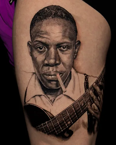 Realistic black and grey Robert Johnson portrait tattoo, by Domi (based in Coventry, UK)