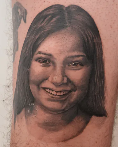 Realistic black and grey young girl portrait thigh tattoo, by Domi (based in Coventry, UK)