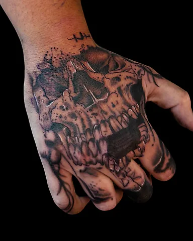 Realistic black and grey skull hand tattoo, by Domi (based in Coventry, UK)